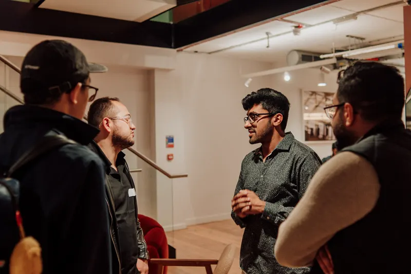 Four founders stand in a loose circle and talk at Growth Night in London.
