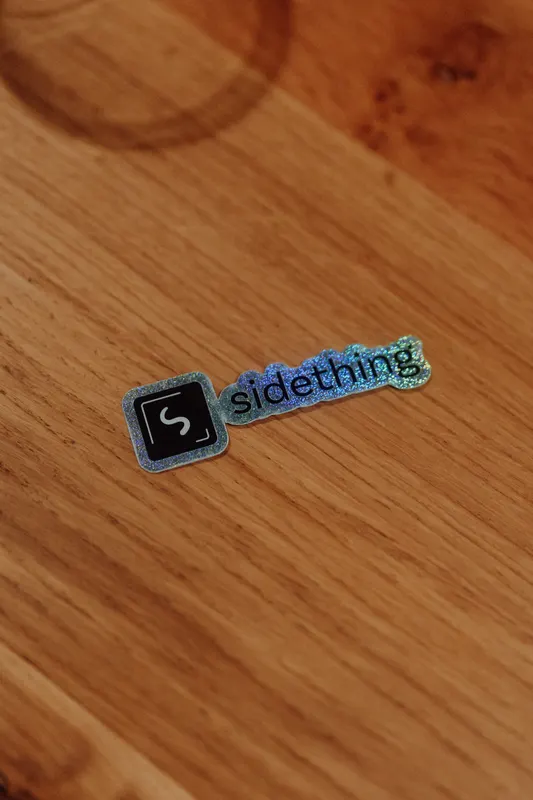 A close view of a shiny sidething sticker lying on an oak table.